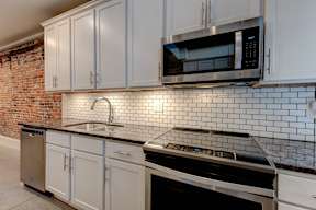 A kitchen with white cabinets and a black stove top oven.