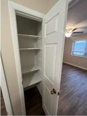 an empty closet in a home with a window