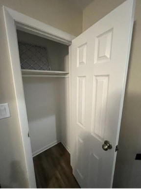 a white door in a white room with a wooden floor