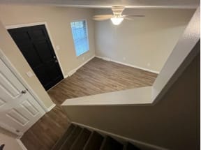 an empty room with a ceiling fan and a door