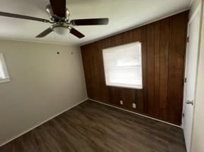 an empty room with a ceiling fan and a window