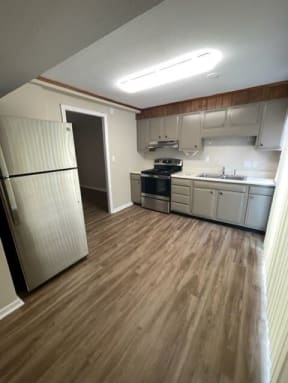 a kitchen with a white refrigerator freezer next to a stove top oven