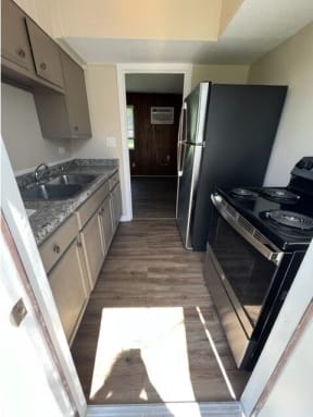 a kitchen with a stove a refrigerator and a sink