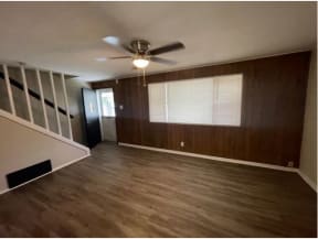 an empty room with a ceiling fan and a window