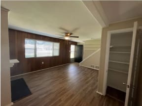 a living room with a wooden floor and a ceiling fan