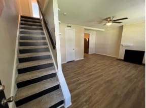 a room with a staircase and a ceiling fan