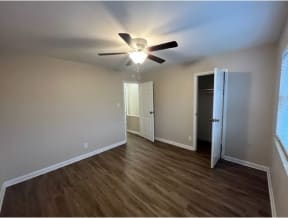 a room with a ceiling fan and hardwood floors