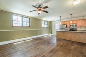 an empty kitchen and living room with a ceiling fan