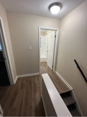a hallway with wood floors and a white door