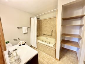 a bathroom with a tub and a sink and a closet