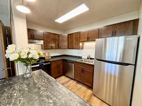 A kitchen with a granite countertop and stainless steel appliances.