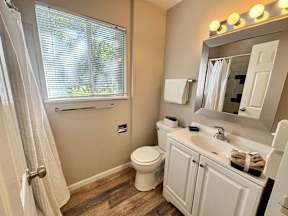 A bathroom with a toilet, sink, and mirror.