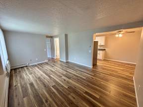 A room with wooden flooring and white walls.