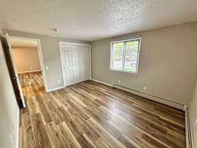 A room with wooden flooring and a window.