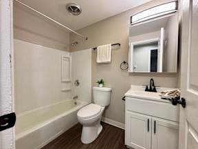 A white toilet sits in a bathroom next to a sink.