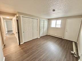A room with wooden floors and white doors.