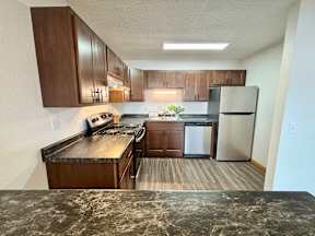 A kitchen with wooden cabinets and a granite counter top.