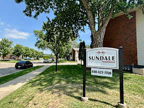 A sign for Sundale townhomes with a phone number on it.