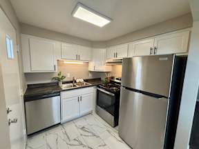 A kitchen with a refrigerator, sink, and oven.
