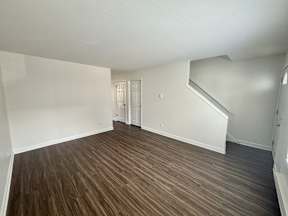 A room with wooden flooring and white walls.