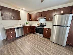 A kitchen with a stainless steel refrigerator, dishwasher, and oven.
