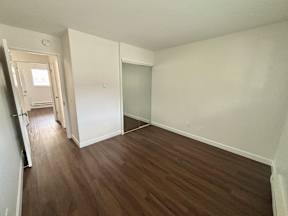 A room with wood flooring and white walls.
