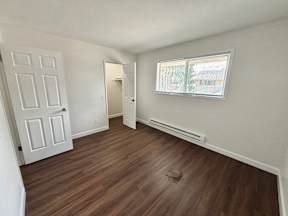 A room with a white door and a window with blinds.