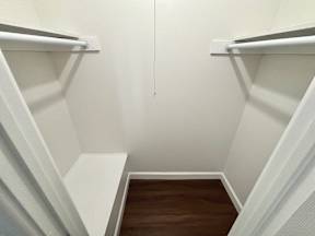 A white hallway with a wooden floor and white walls.