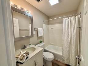 A small bathroom with a white toilet, sink, and shower.