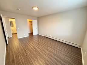 A room with wooden flooring and white walls.