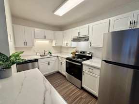 A kitchen with white cabinets and stainless steel appliances.
