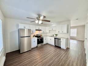 A spacious kitchen with a refrigerator, stove, and oven.