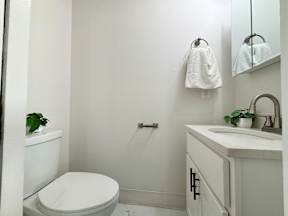 A white toilet sits next to a sink in a bathroom.