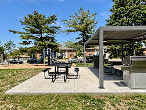 A picnic area with a table and chairs under a shelter.