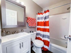 A white bathroom with a toilet, sink, and shower curtain.