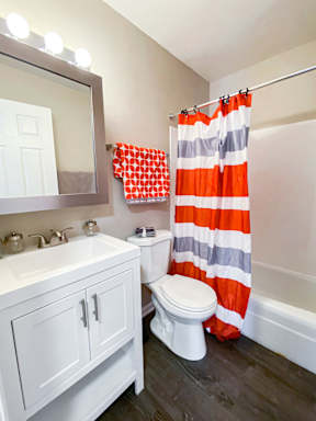 A white bathroom with a striped shower curtain.