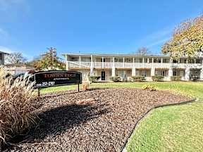 A sign for Down's Ridge Apartments is in front of a building.