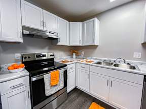 A kitchen with white cabinets and a black stove top.