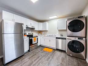 A modern kitchen with a stainless steel refrigerator and a dishwasher.