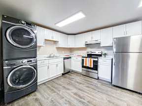 A modern kitchen with a washer and dryer stacked on top of each other.