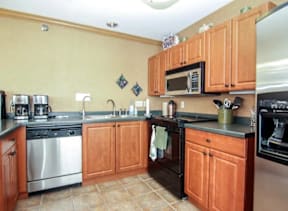 A kitchen with wooden cabinets and a tile floor.