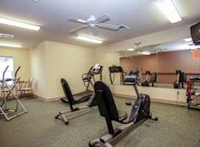 A gym room with treadmills, exercise bikes, and other equipment.