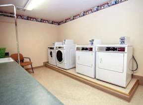 A laundry room with a washer and dryer on the wall.