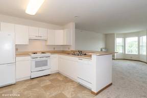 A kitchen with white appliances and cabinets.
