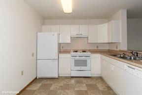 A kitchen with white appliances and cabinets.