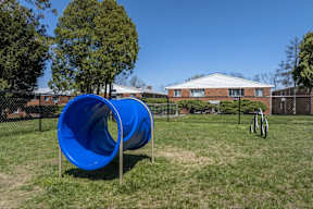 A blue slide in a playground with a building in the background.