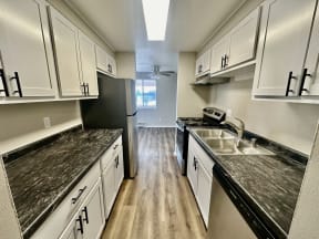 a kitchen with marble counter tops and white cabinets