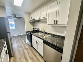 an empty kitchen with white cabinets and stainless steel appliances