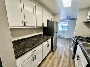 a kitchen with white cabinets and a stainless steel refrigerator