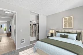 Bedroom in Oro apartment home with plush carpeted flooring, large windows, and spacious closet.